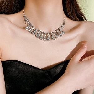 Macro shot of silver teardrop tassel necklace with rhinestones on a female model