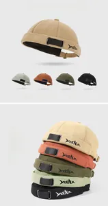 Detail of embroidered letters on multi-colored vintage docker hats with metal buckles