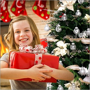 Girl holding red gift box with polka dot ribbon in front of a festive Christmas tree
