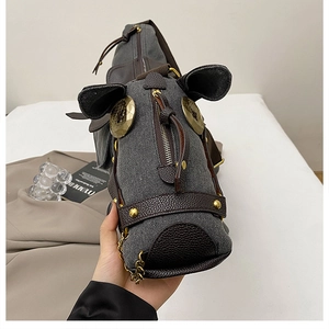 Detailed close-up of a creative horse-shaped canvas bag with leather patchwork and chain