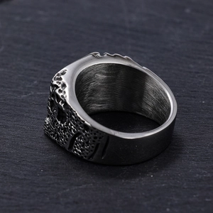 Macro shot of silver skull ring detail showing vintage steel texture and brushed inner band