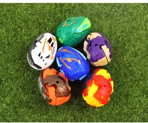 Top view of six colorful dinosaur transformation eggs on a green grass background