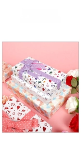 Detail of Valentine's gift boxes wrapped in colorful heart pattern paper with purple ribbon