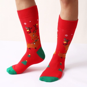Festive red Christmas crew socks featuring reindeer and tree patterns on a model