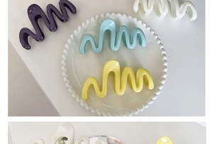 Macro view of colorful wavy hair claws in cream purple white blue and yellow acrylic
