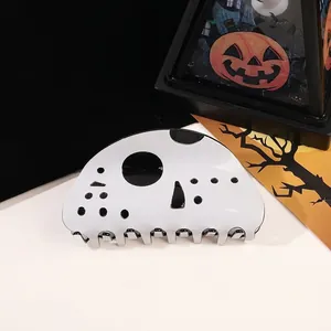 Macro detail of Halloween hockey mask hair claw clip on dark festive background