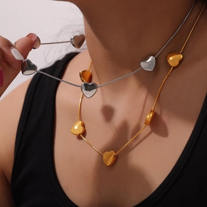 Elegant gold and silver titanium heart pendant necklaces on model for a chic style