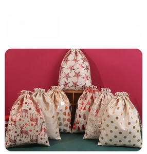 Detail of Christmas burlap gift bags with elk and tree patterns and drawstring closure