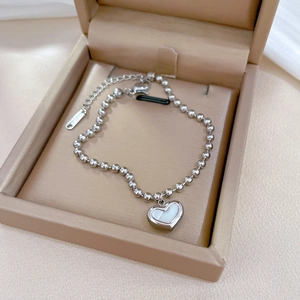 Detail view of silver stainless steel beaded bracelet with heart mother of pearl charm