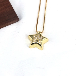 Detail of a gold star pendant with letter W inlay on a textured background