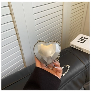 Detailed view of silver heart-shaped mini bag with geometric diamond cut texture and chain