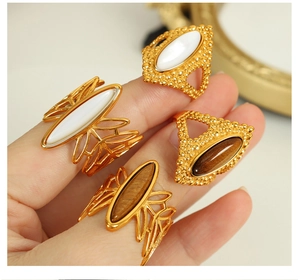 Macro detail of bohemian gold rings with hollow patterns and tiger eye stones