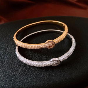 Detail of 18K gold and silver plated pave bracelets with circular clasp on velvet