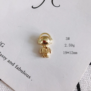 Detail of golden astronaut pendant with heart motif measuring 19 by 12mm on card