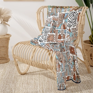 Detail showing bohemian flannel blanket with Sun Shine print on a rattan chair