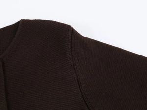 Vue détaillée de l'épaule et de l'encolure d'un tricot marron foncé avec coutures fines