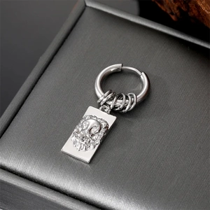 Silver titanium steel huggie earrings with lion head relief in a gray jewelry box