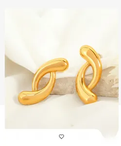 Macro shot of 18k gold plated stainless steel twisted hoop earrings on white stone
