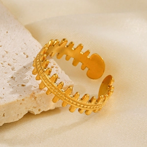 18K gold plated stainless steel fishbone ring on a beige stone and cream silk fabric