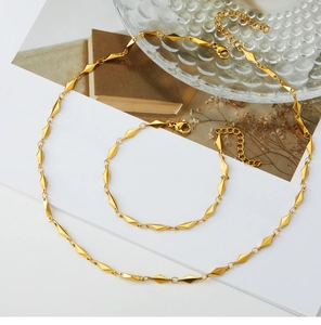 Flat lay of luxury gold geometric rhombus necklace and bracelet set on a white card