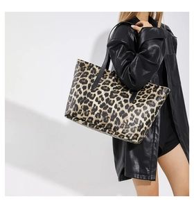 Modella che indossa una grande borsa tote leopardata con giacca di pelle nera