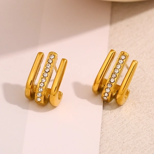 Detailed macro view of 18K gold plated J-shaped earrings with three rows of sparkling zircon