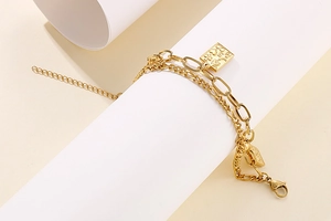 Detail of gold double-layer chain bracelet with rectangular pendant and lobster clasp