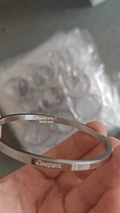 Dettaglio macro del bracciale in acciaio inossidabile argento con incisioni Forever