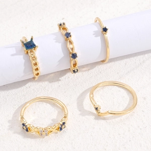 Five-piece gold ring set for women featuring deep blue stones and sparkling crystals