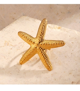Macro detail of oversized starfish ring with textured golden beads on stone