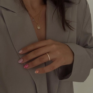 Detail of 18k gold plated lock pendant and letter A necklace set on a model