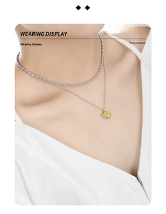 Close-up of a double-layered gold heart necklace with radial texture on a woman collarbone