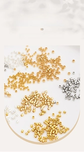 Macro detail of 14K gold-filled crimp beads and tubes for DIY jewelry making supplies
