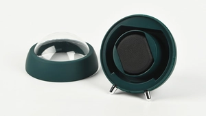 Detail of a dark green automatic watch winder with acrylic dome and black sponge pillow