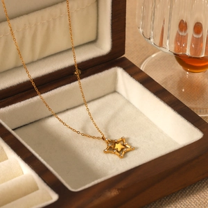 Golden stainless steel necklace with hollow star pendant in a wooden jewelry box