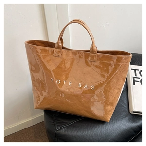 Close-up of caramel tote bag with TOTE BAG text and glossy crinkle texture