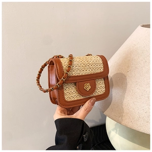 Detailed shot of brown leather and beige straw patchwork mini bag with floral metal lock