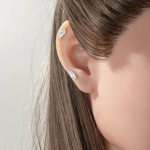 Elegant silver wing screw back stud earrings set on ear for men and women