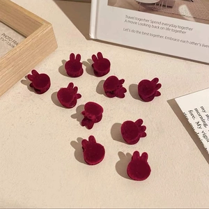 Set of 10 red velvet rabbit hair clips for girls displayed on a minimalist background