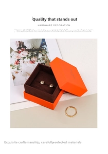 Detail view of gold stud earrings and ring inside a premium orange velvet jewelry box