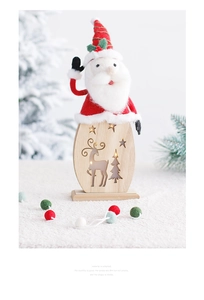 Close-up of LED glowing wooden Santa Claus ornament with red fabric and rustic details