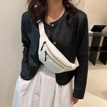 Bolso de pecho blanco minimalista con correa ajustable en modelo con chaqueta de cuero negra