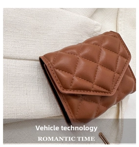 Macro shot of brown quilted leather texture and fine stitching on a small handbag