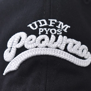 Black washed cotton baseball cap featuring white 3D embroidery detail and adjustable strap