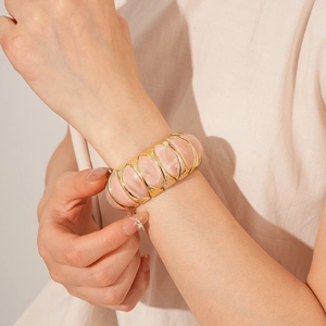 Macro shot of chunky vintage resin bangle with pink marble texture and gold accents