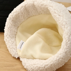 Détail de la texture laine d'agneau blanche et doublure polaire chaude du chapeau