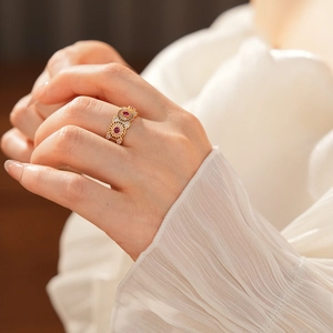 Dettaglio dell'anello placcato oro 18k con gemma rossa e accenti di zircone lucido