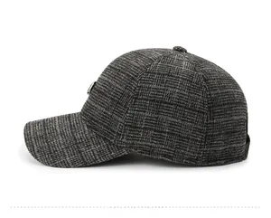 Detail view of dark grey plaid baseball cap with wool texture and metal logo stud