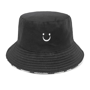 Detail of black bucket hat with white spray-paint smile embroidery and stitched brim