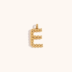 Macro detail of gold-plated letter E pendant with twisted rope texture and high polish